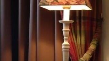 Una mesa con una lámpara, un par de zapatos y un paño doblado.