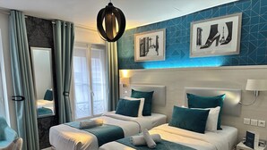 A hotel room with two beds, a large mirror, and artwork on the wall.
