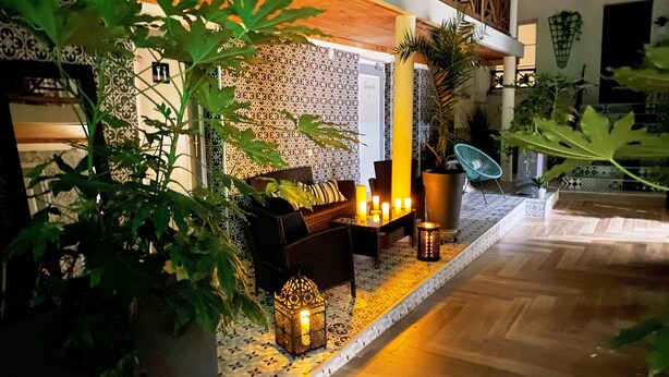 A cozy indoor seating area with a patterned wall, a wooden ceiling, and a tiled floor.