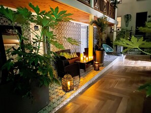 Un espacio interior acogedor con un muro estampado, techo de madera y suelo de baldosas.