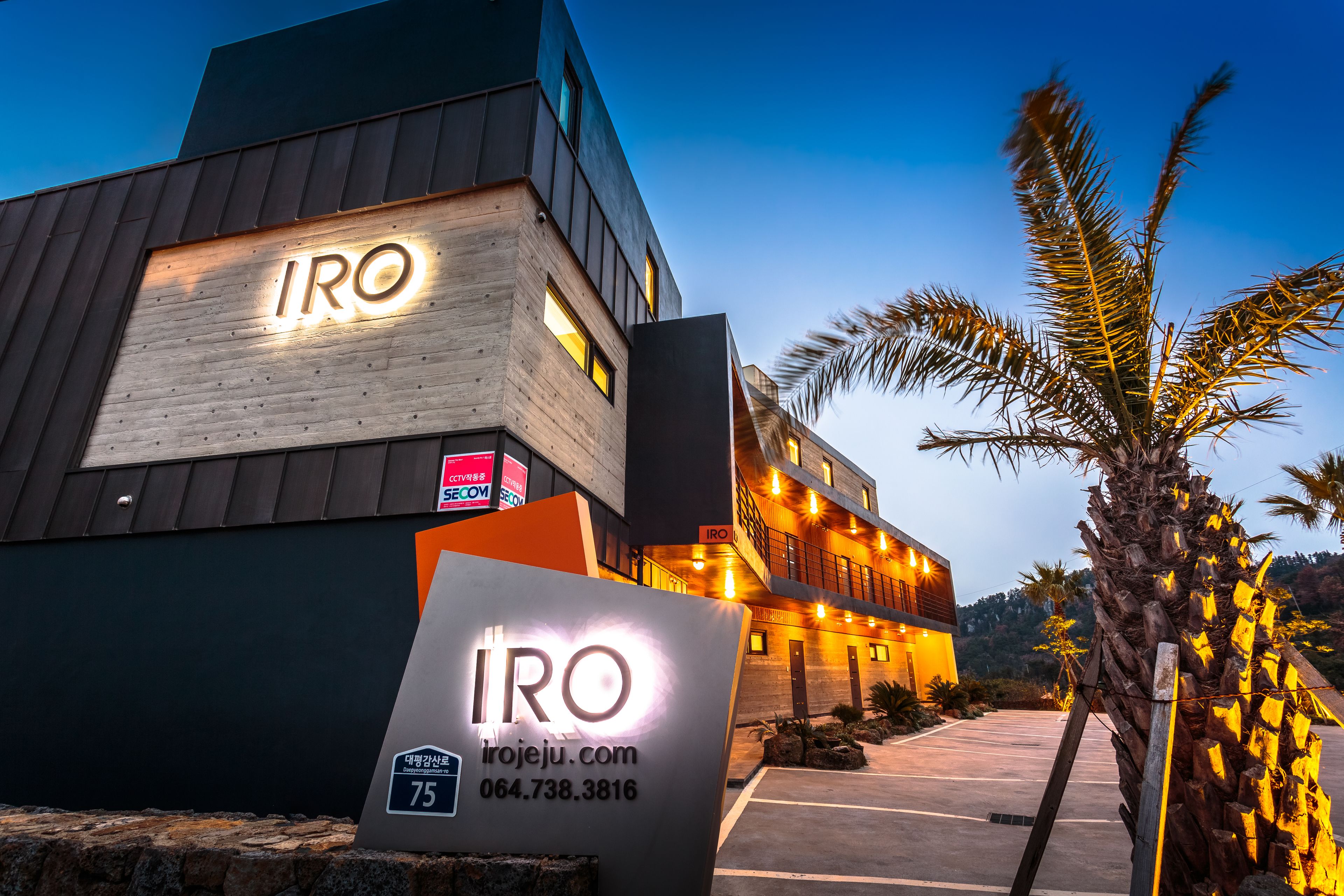 Un edificio moderno con il nome 'IRO' illuminato sulla facciata.