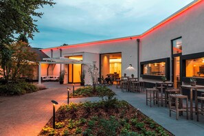 An outdoor patio area with seating and a small garden. - Mintrops Land Hotel Burgaltendorf (Essen)