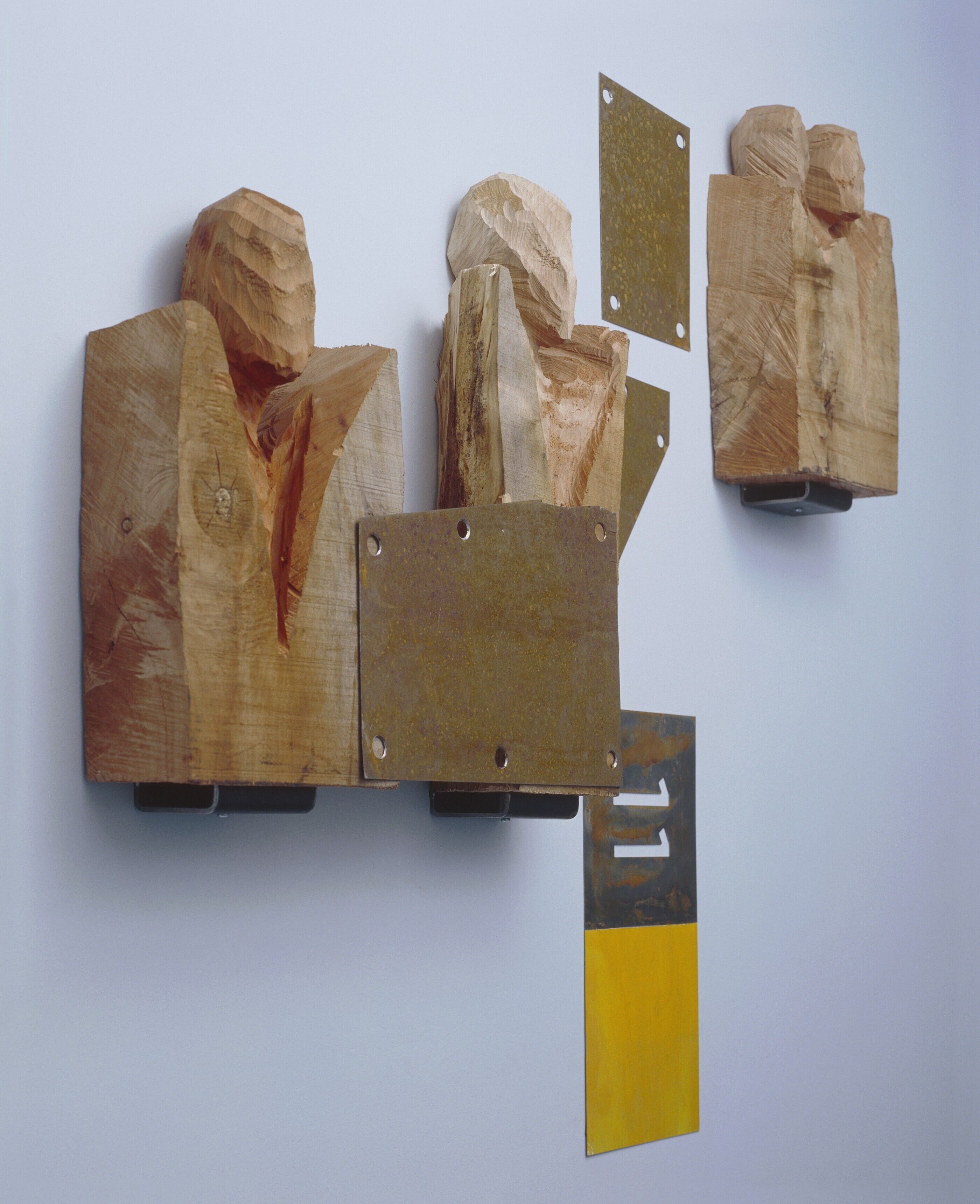 A wall with various wooden panels and a yellow rectangular piece.