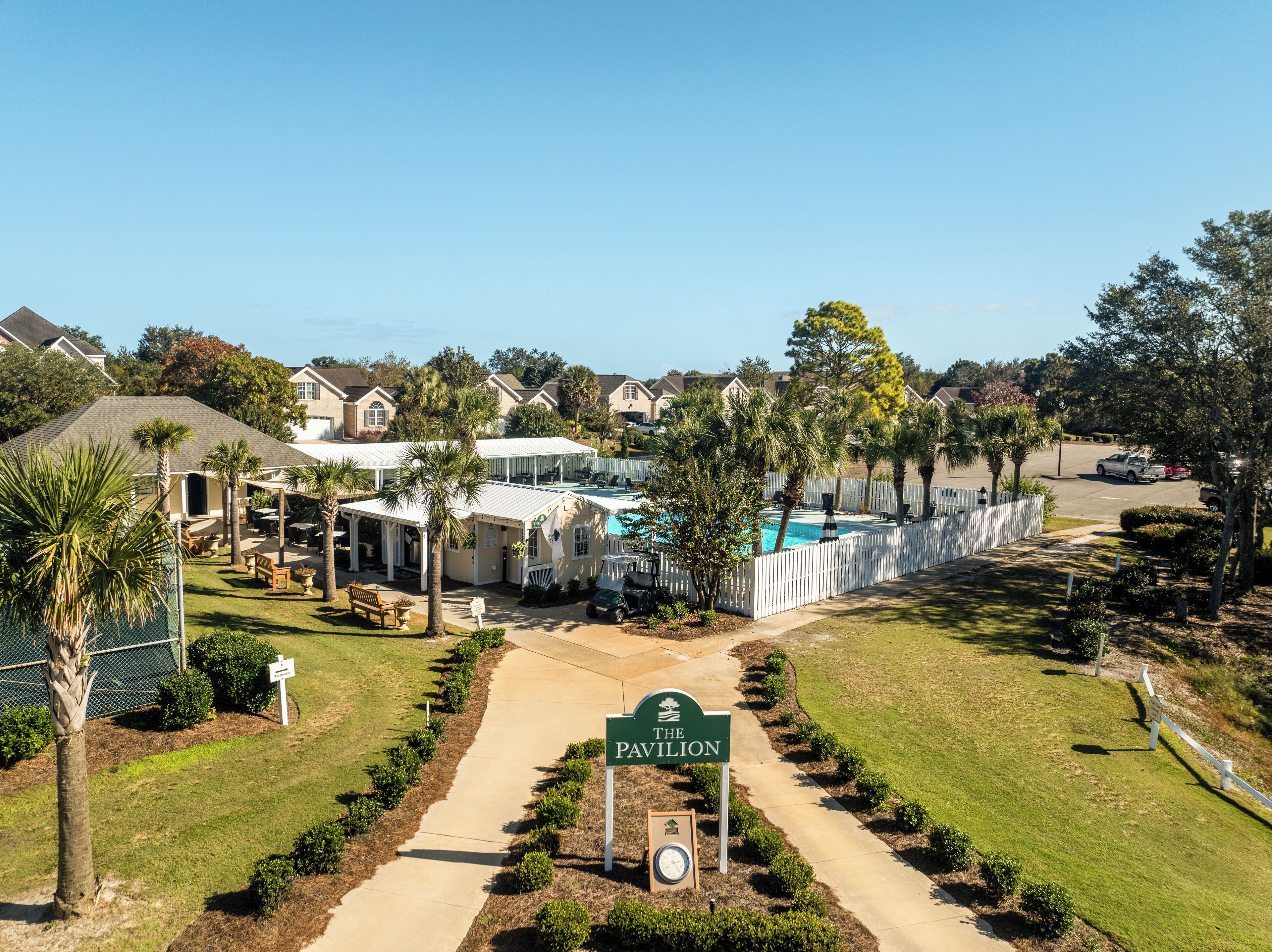A golf course with a clubhouse, a swimming pool, and a sign reading "The Pavilion".