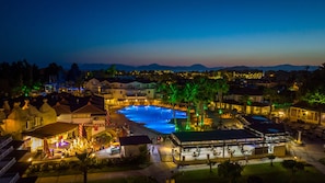 Um resort com piscina, área de estar externa e vista para as montanhas.
