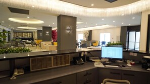 A modern office space with a reception desk, computer, and seating area.