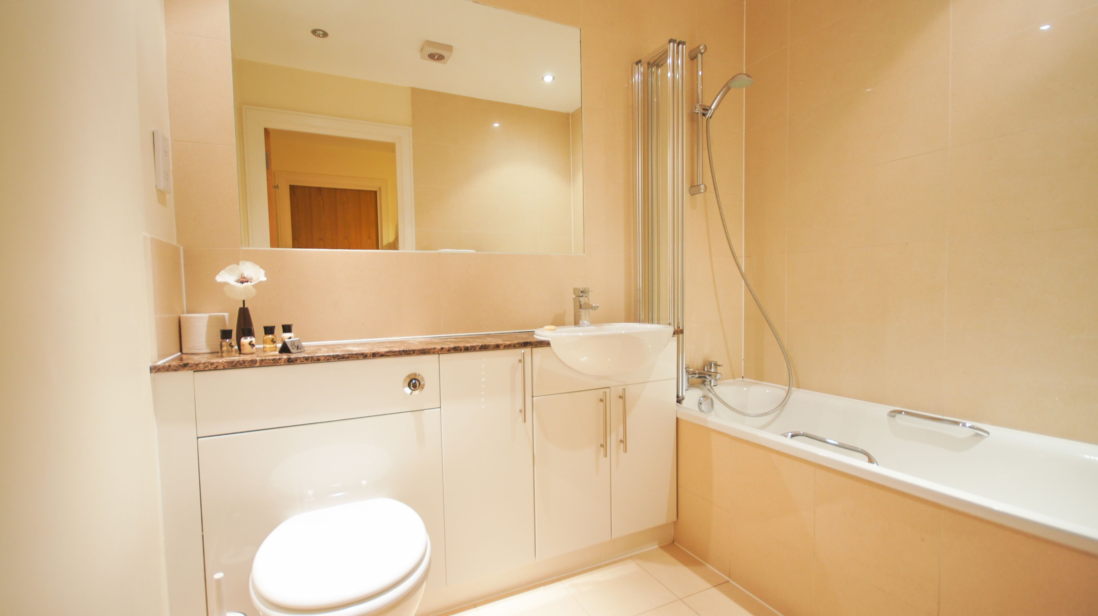 A modern bathroom with a toilet, sink, and bathtub.