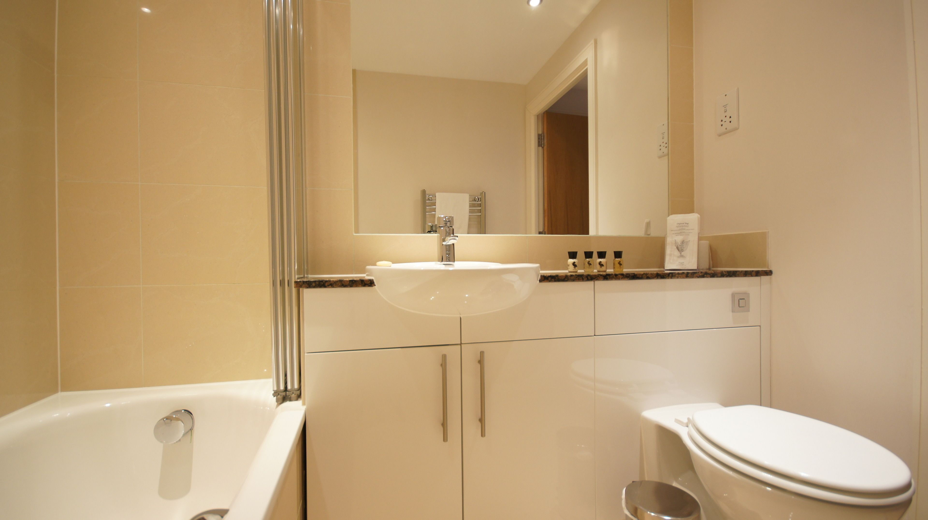 A modern bathroom with a bathtub, sink, and toilet.