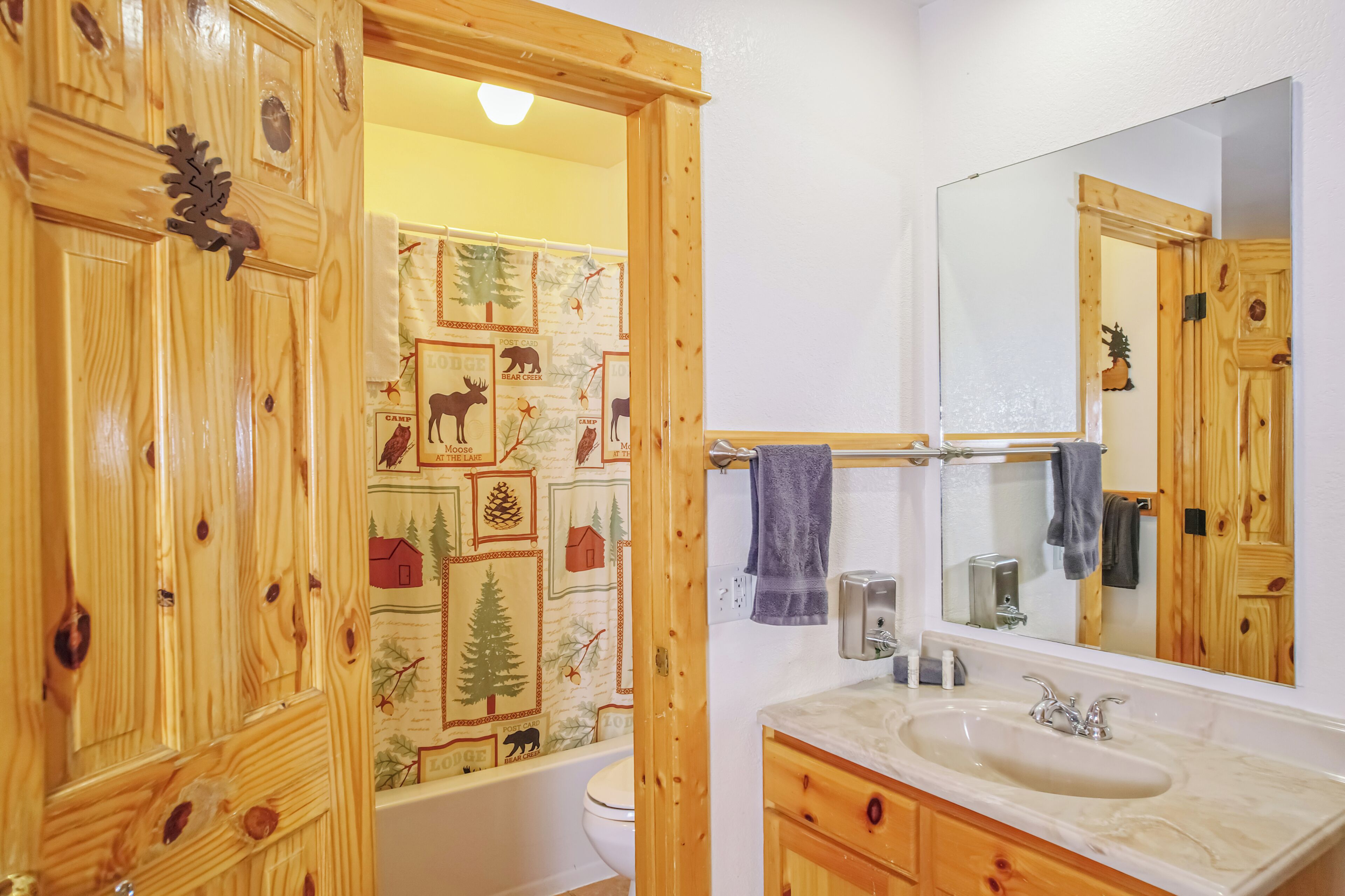 Un baño con muebles de madera, una bañera, un lavabo y un espejo.