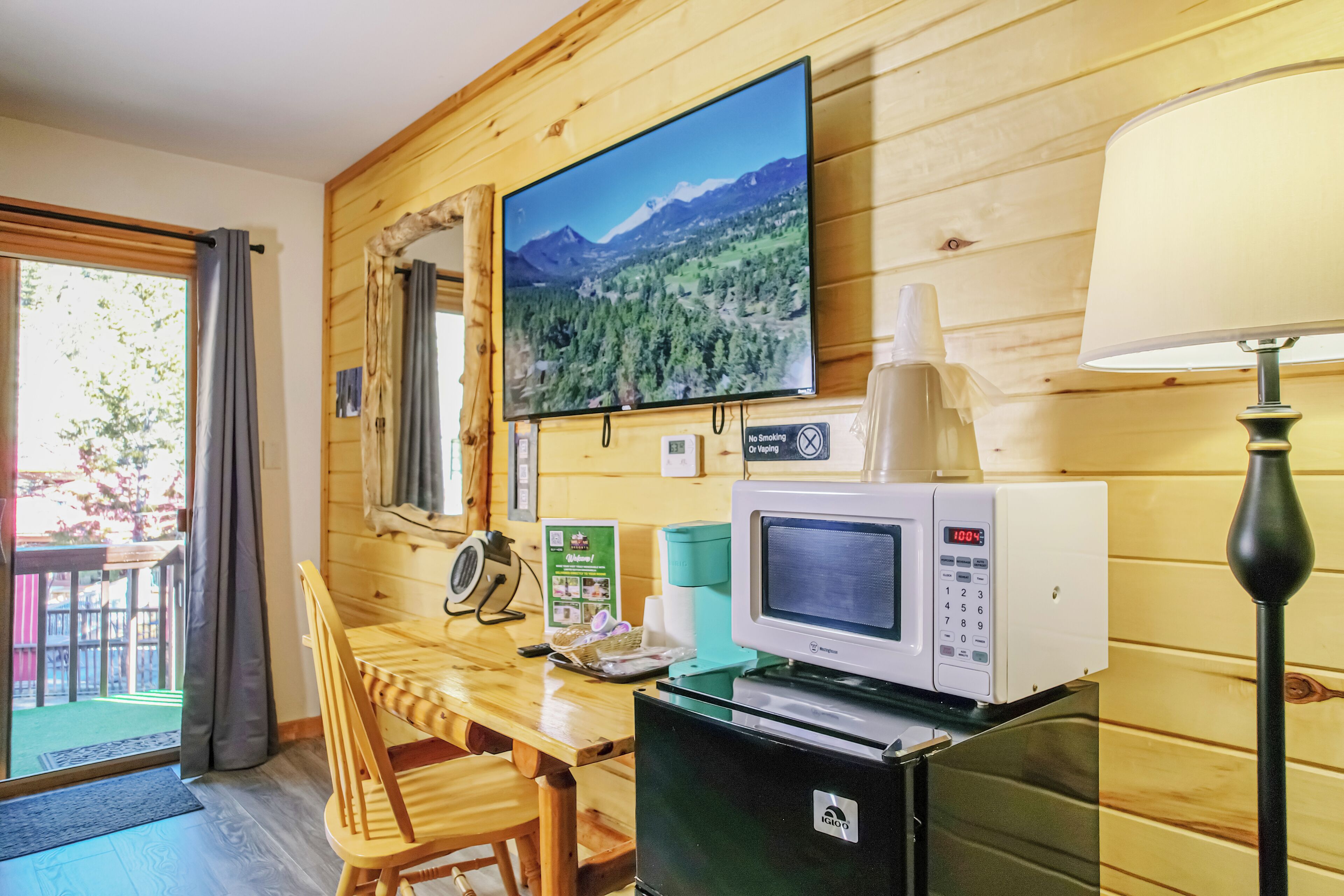 A wooden interior with a television, microwave, and table with chairs.