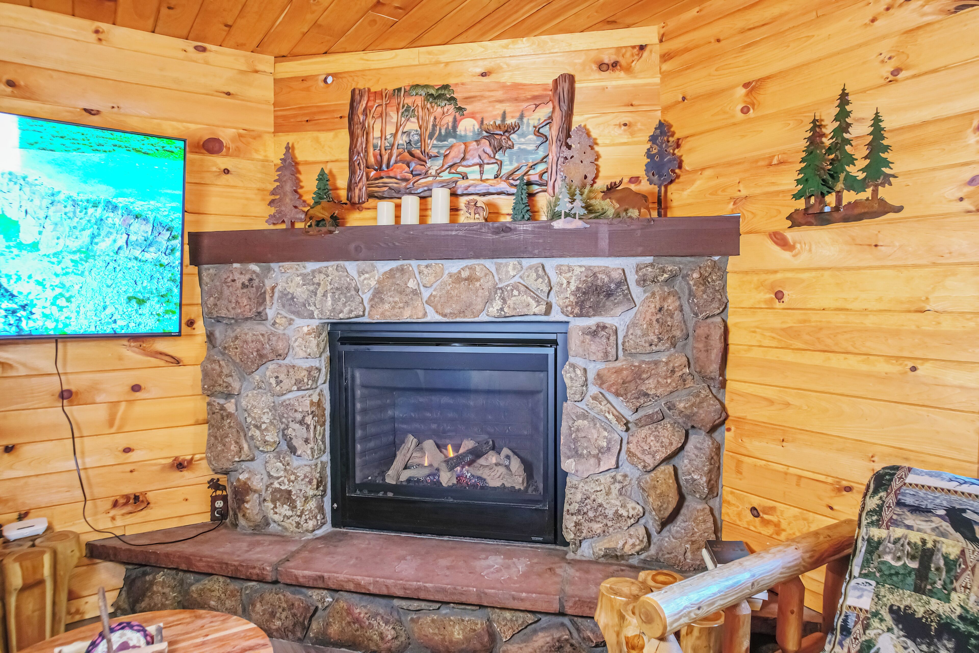 A stone fireplace with a television mounted on the wall above it.