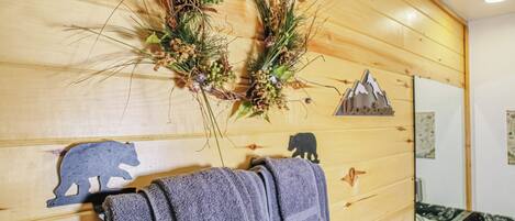 Eine Holzwand mit Handtuchhalter, einer Girlande und Bärenformen.