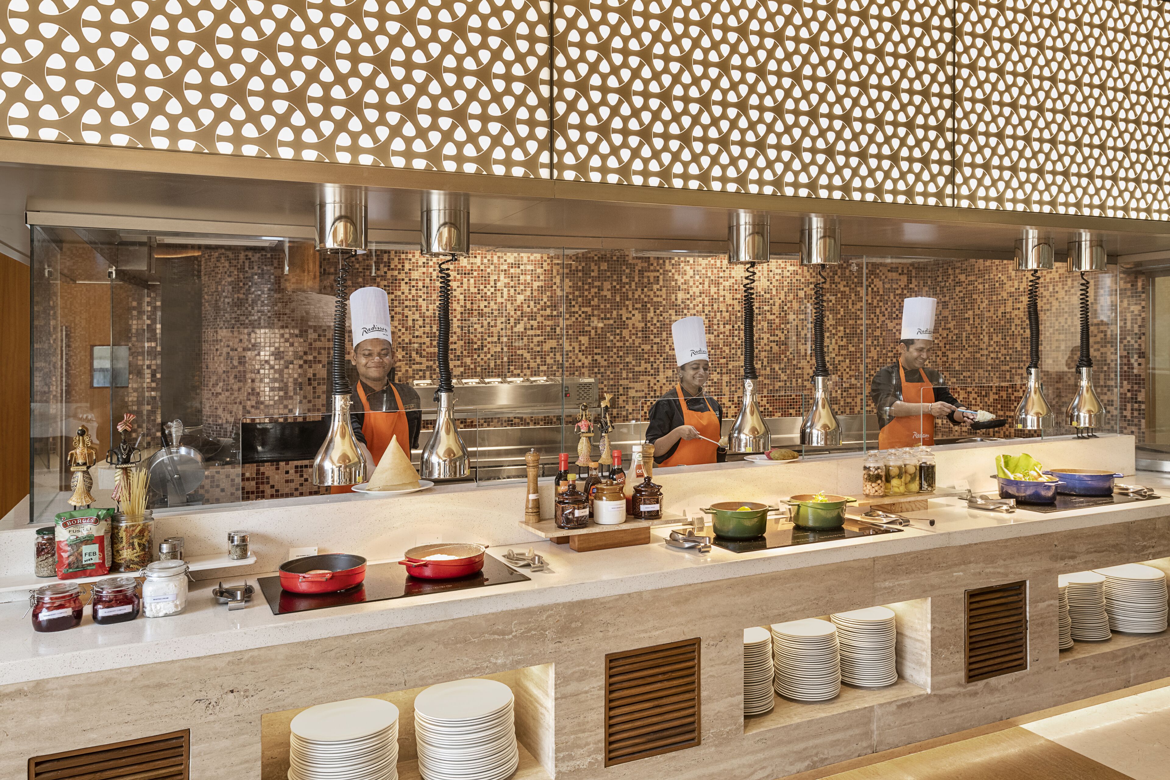 Een buffetopstelling met meerdere aanzitellingen, diverse gerechten en stapels borden.