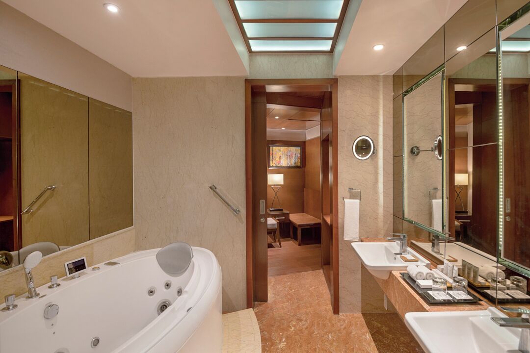 A modern bathroom with a large bathtub, dual sinks, and a walk-in shower.