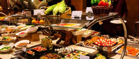 A buffet with various food items and a person in the background.