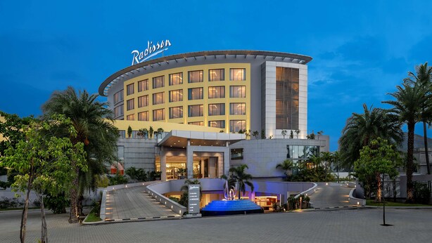 A hotel with a curved facade, multiple floors, and a prominent sign.