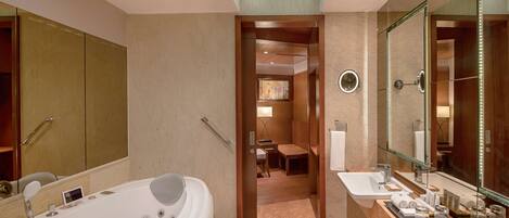 Un baño moderno con una bañera grande, un tocador con espejo y una zona de ducha.