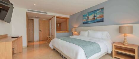 A modern bedroom with a bed, bedside table, and a painting on the wall.