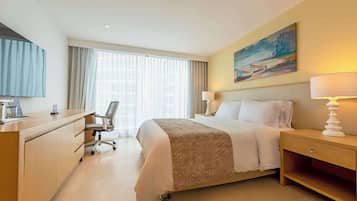 Ein Hotelzimmer mit Bett, Schreibtisch, Stuhl und einem Bild an der Wand.