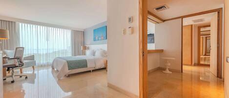 Una camera d'albergo con un letto, una scrivania con una sedia, una lampada e un quadro appeso al muro.