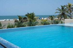 Una piscina al aire libre, sillones reclinables de piscina