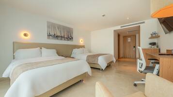 A hotel room with two beds, a desk, a chair, a painting on the wall, and a wooden door leading to another room.