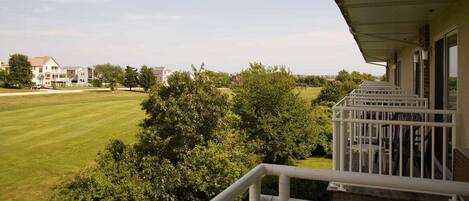 A residential area with a house, a well-maintained lawn, and a balcony with a railing.