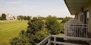 A residential area with a house, a well-maintained lawn, and a balcony with a railing.