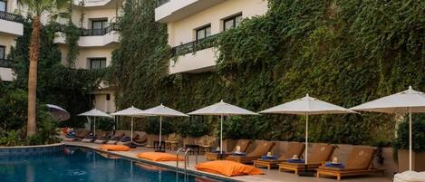 Una piscina al aire libre, tumbonas