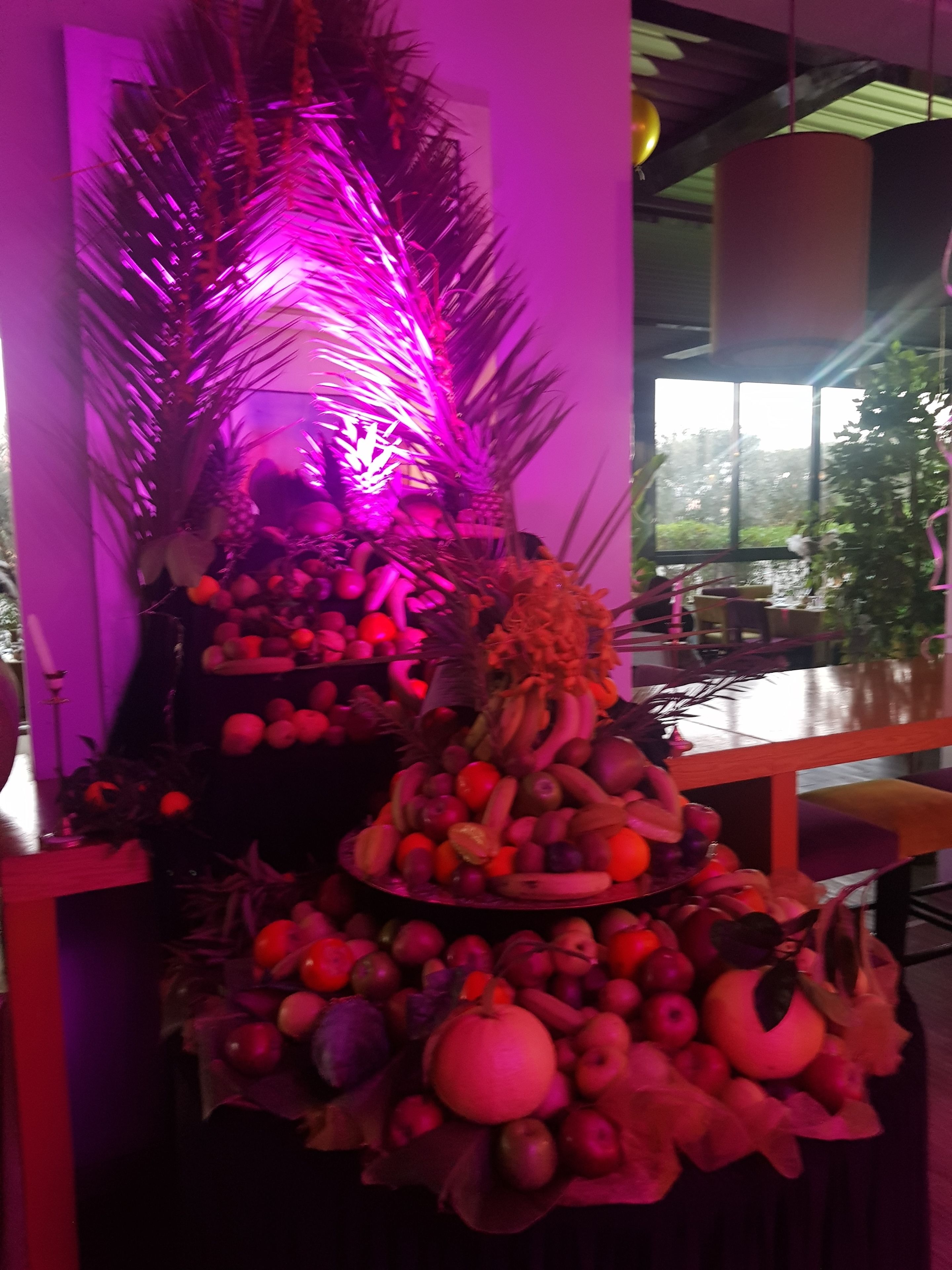 Una exhibición de frutas con diversas opciones y un fondo decorativo.