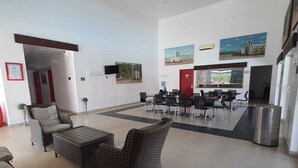 Un vestíbulo amplio con zona de estar, mesa de comedor y obras de arte en las paredes.