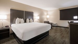 A hotel room with a large bed, two bedside lamps, a desk, and a flat-screen TV. - Best Western Northwest Indiana Inn (Hammond)