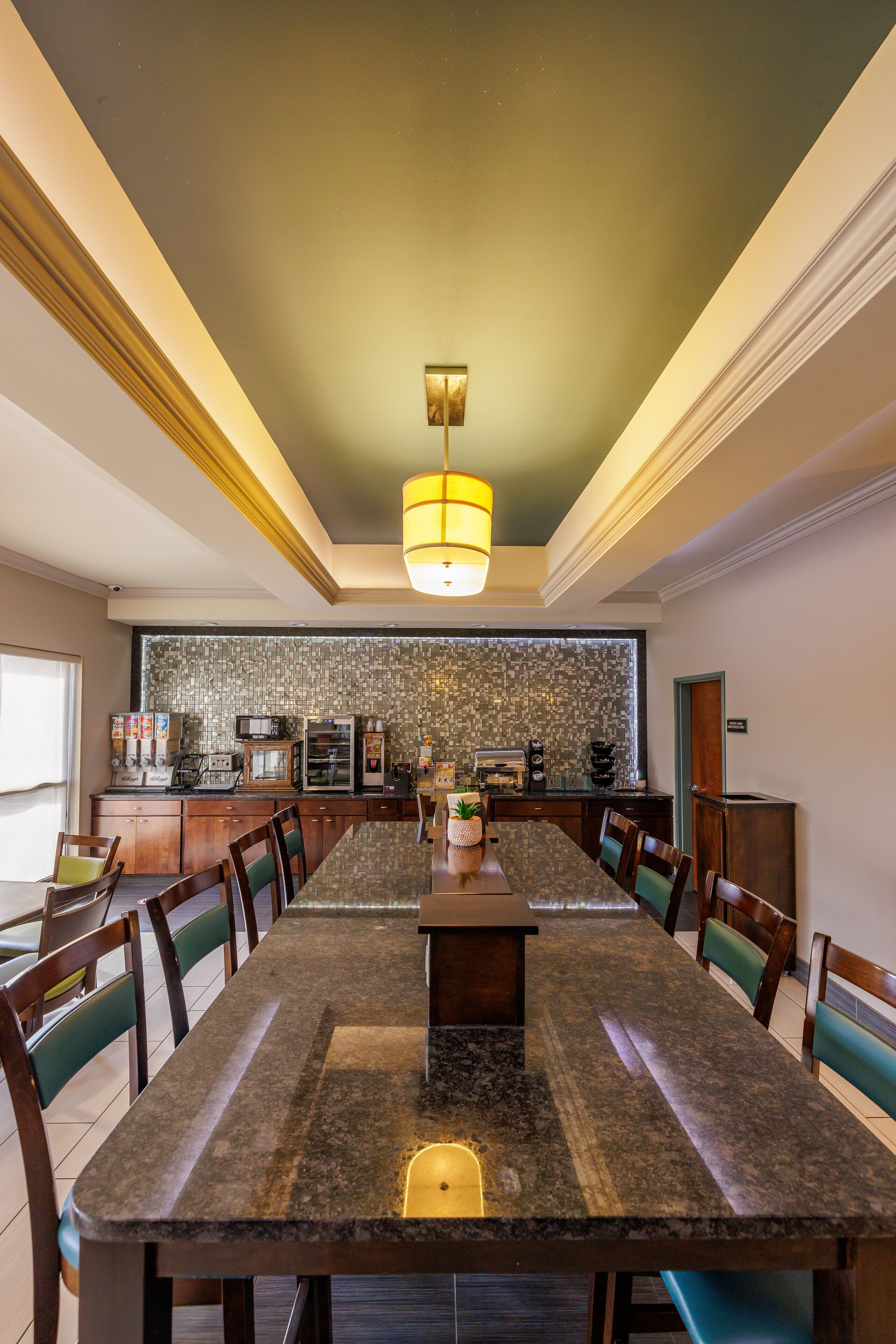 A spacious dining area with a long table, chairs, and a central island.