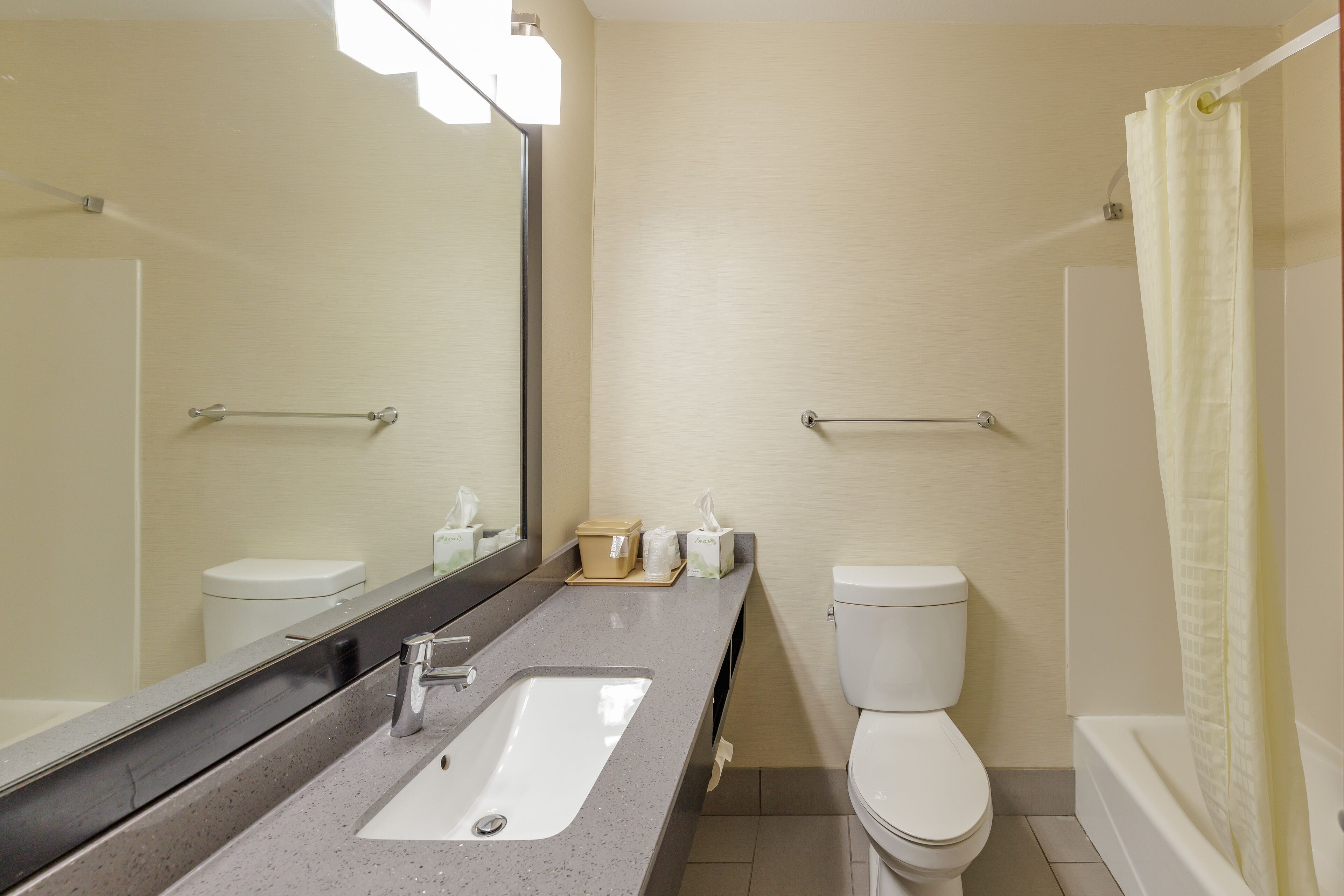 Un baño con lavamanos, inodoro y cortina de ducha.