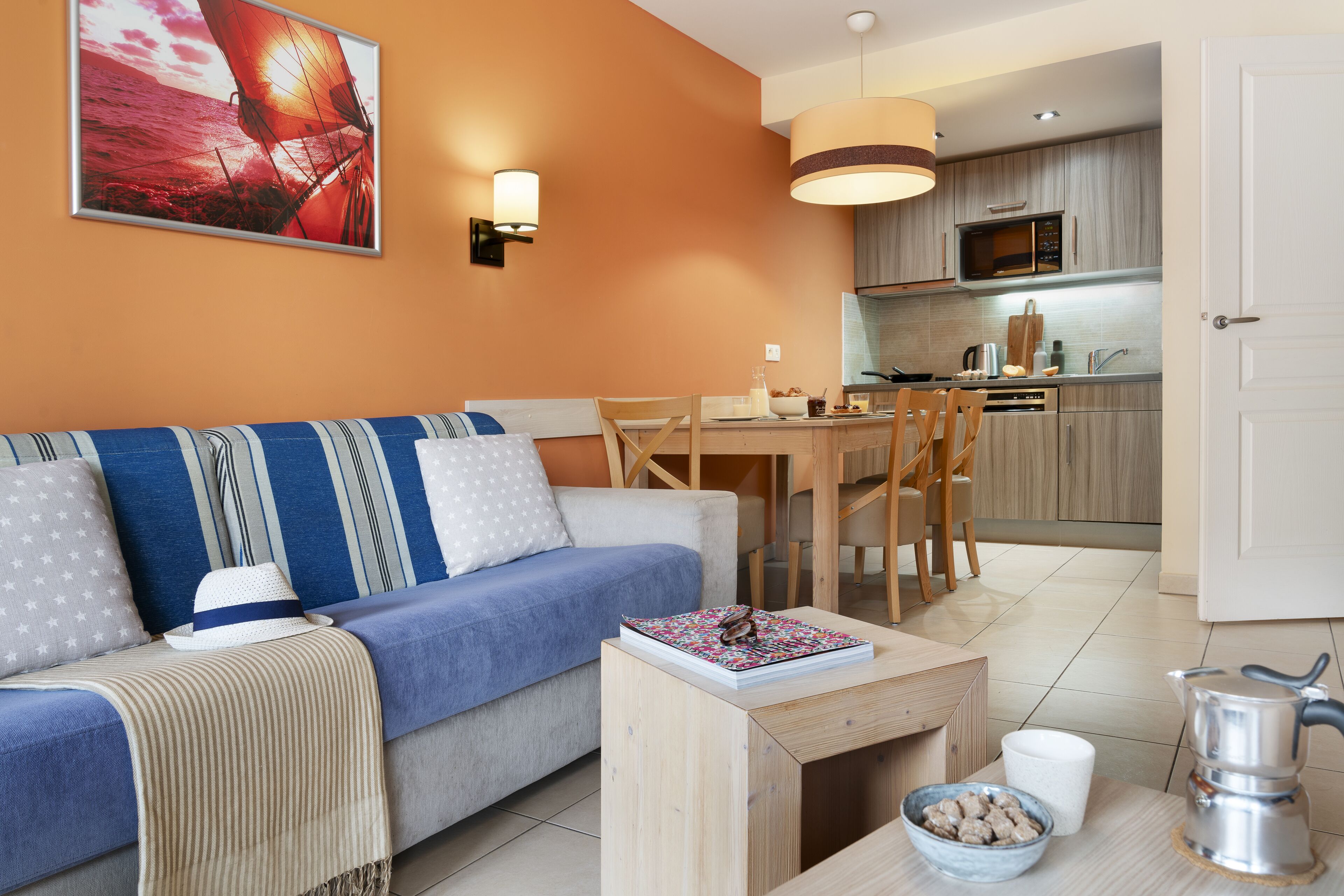 A modern living room with a sofa, coffee table, and dining area.