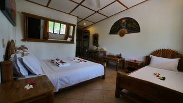 A hotel room with two beds, a ceiling fan, a desk, and a chair.
