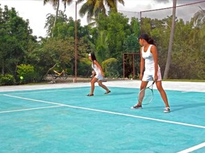 A tennis court with two players in white outfits. - Dolphin House (Moalboal)