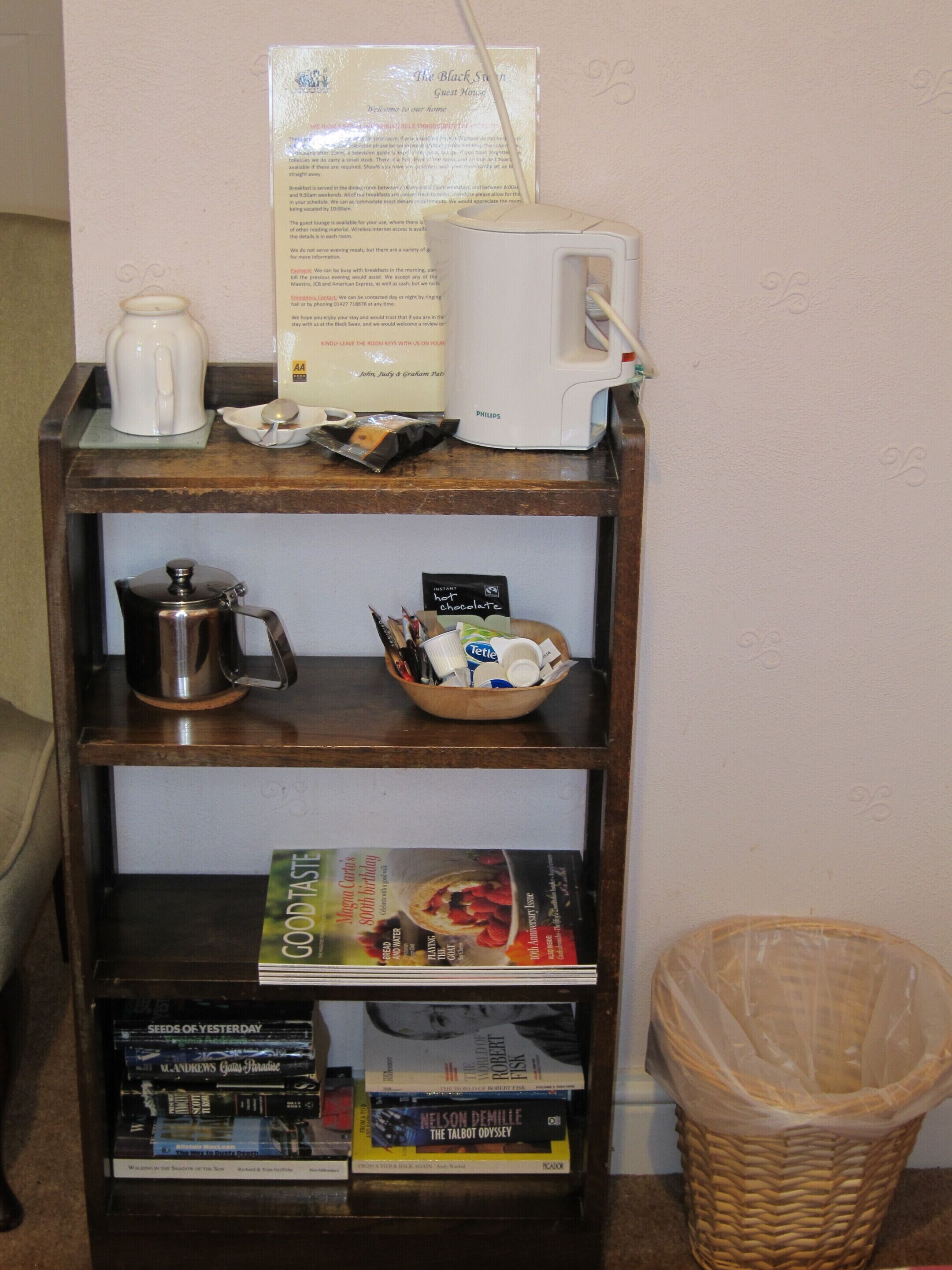 A coffee station with a coffee maker, a kettle, and a bowl of instant coffee packets.