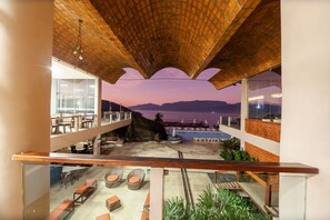 Una terrazza sul tetto con posti a sedere e vista sul mare al tramonto.