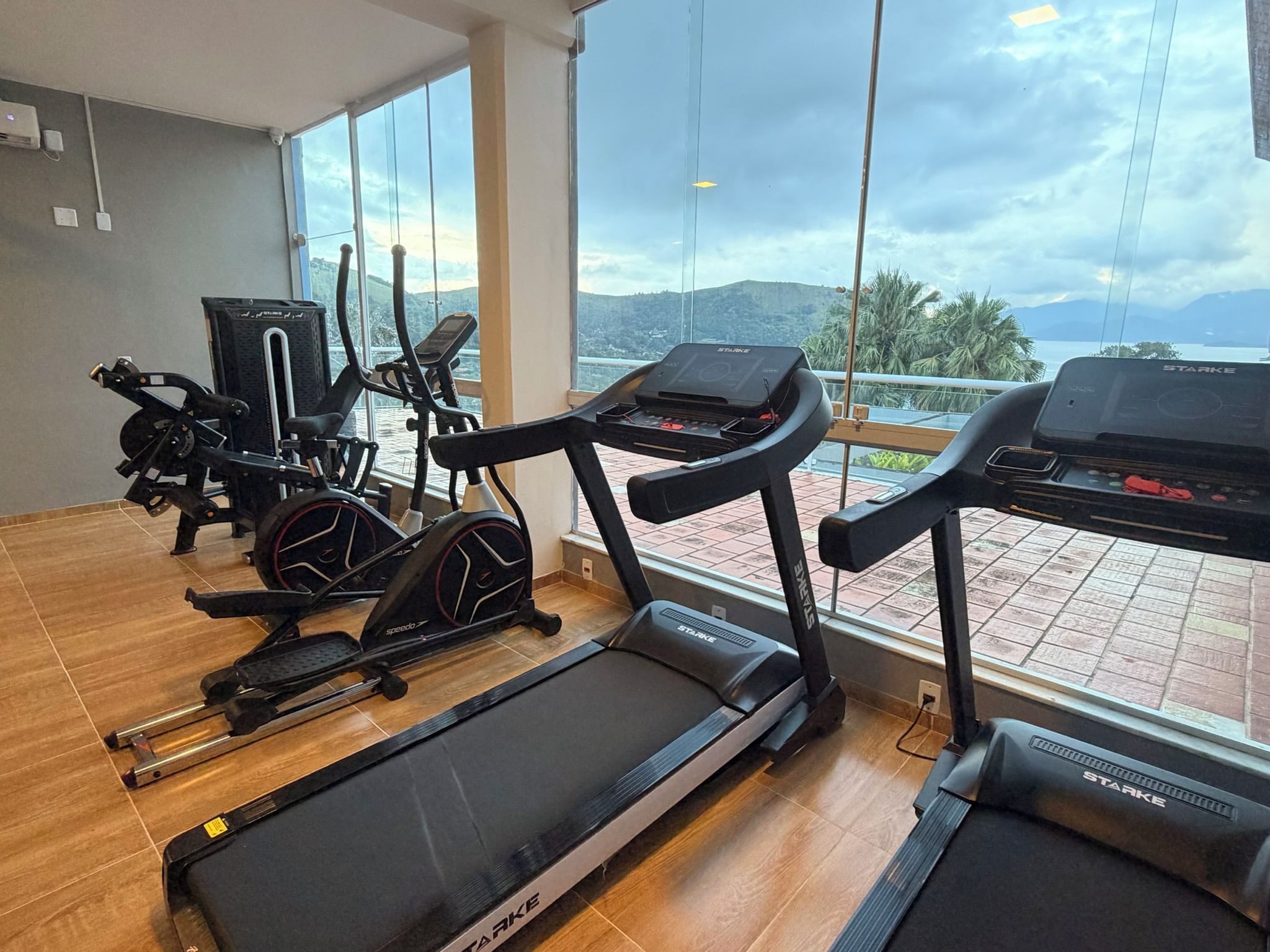 Une salle de sport équipée de tapis de course, de vélos d’appartement et d’un appareil d’aviron.