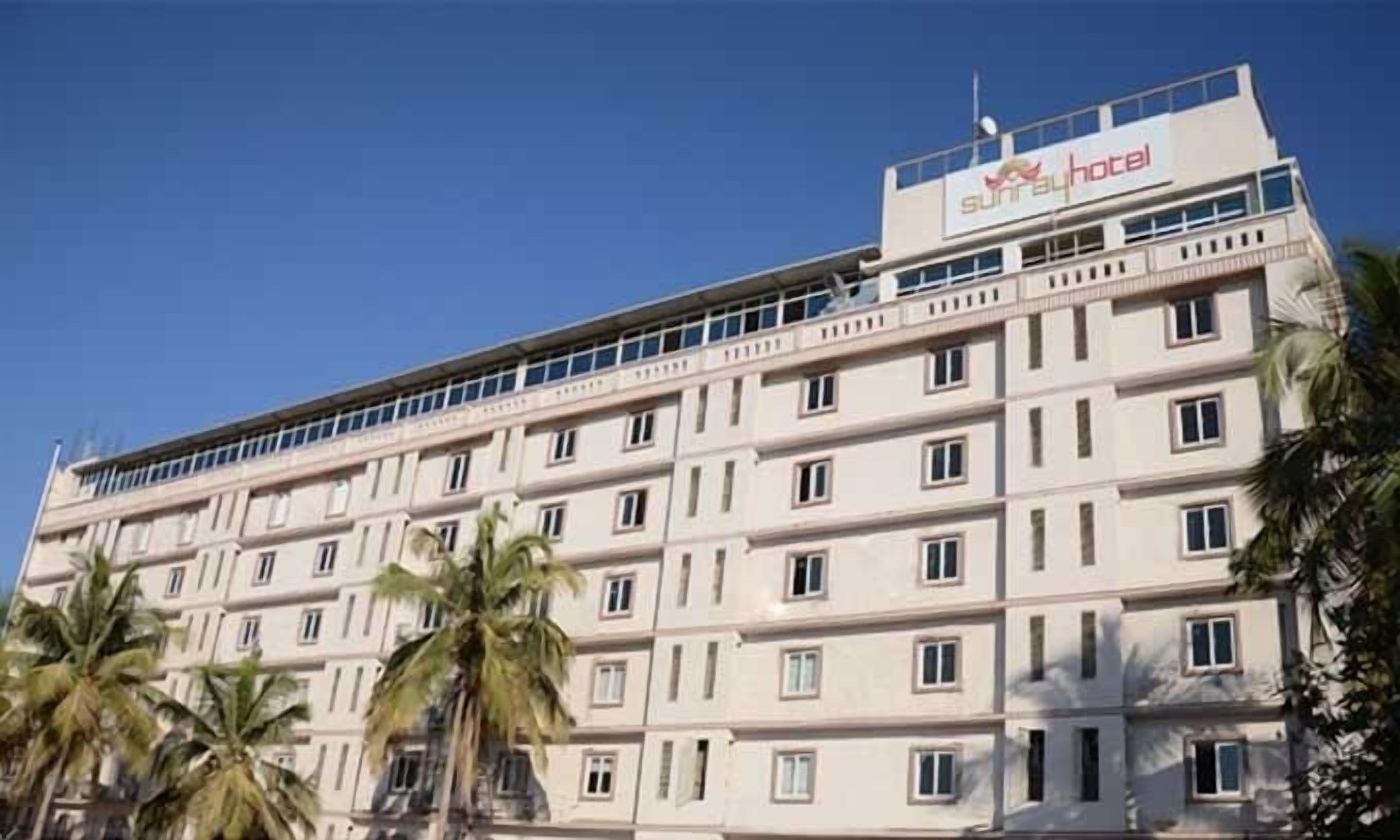 A multi-story hotel with a flat facade, numerous windows, and a sign indicating it is a hotel.