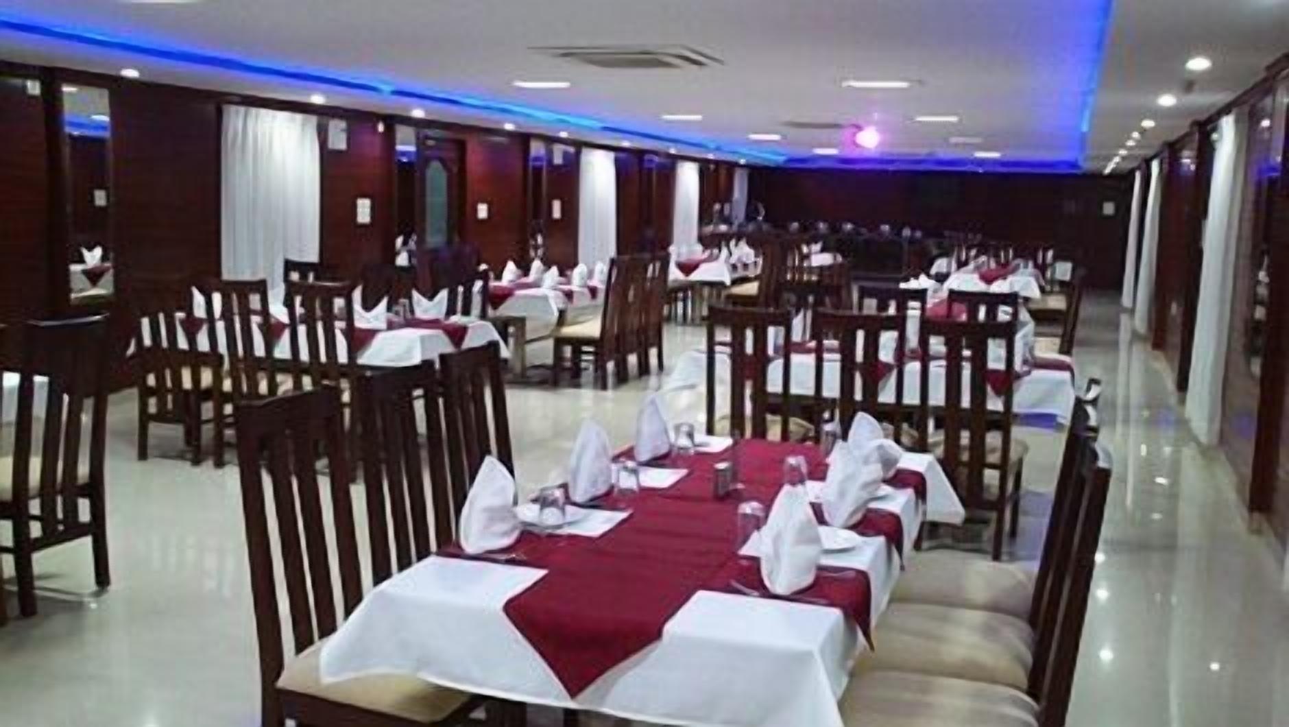 A spacious restaurant with multiple tables set for dining, featuring a clean and modern interior.