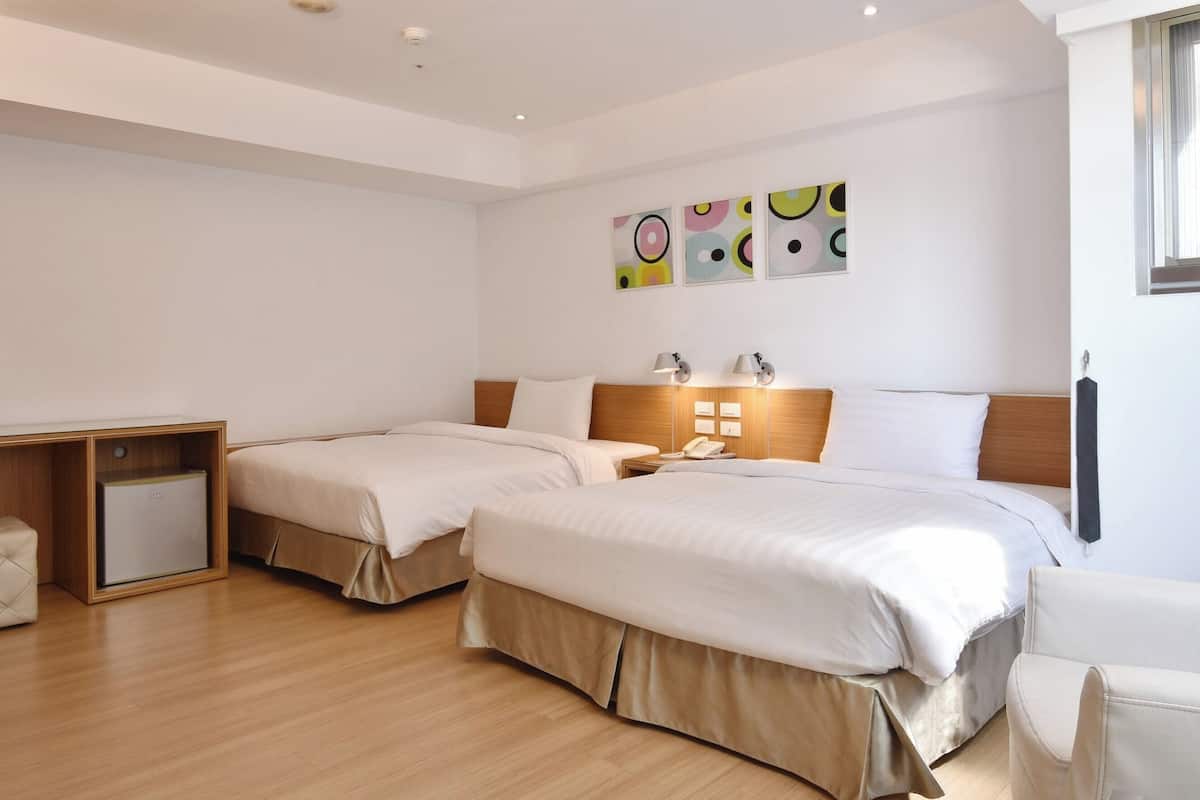 Una habitación de hotel con dos camas, un escritorio y una silla.
