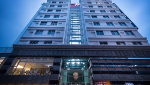 A high-rise hotel with a central atrium, multiple floors, and a prominent 'HOTEL' sign at the top. - Hotel Hi Xinmin (Chiayi City)