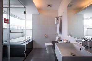 A modern bathroom with a glass shower enclosure, a bathtub, a toilet, and a large mirror. - Hotel Hi Xinmin (Chiayi City)