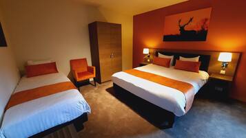 Een hotelkamer met twee bedden, een kledingkast en een schilderij aan de muur.