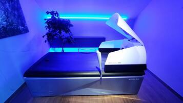 A medical device labeled 'MEDICAL_PLUS' in a room with a blue-lit ceiling and a potted plant.