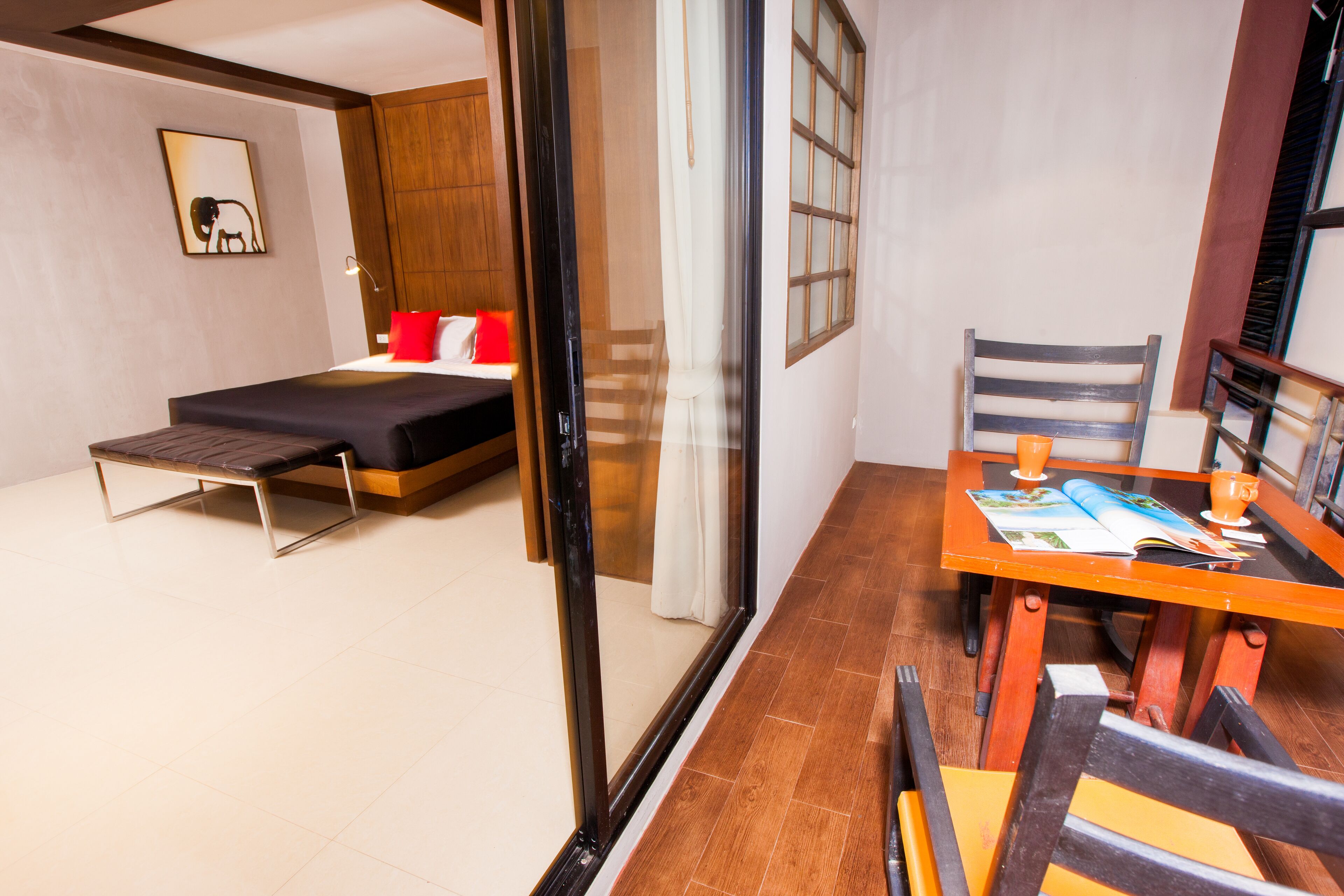 A modern hotel room with a bed, a small table with a magazine, and a chair.