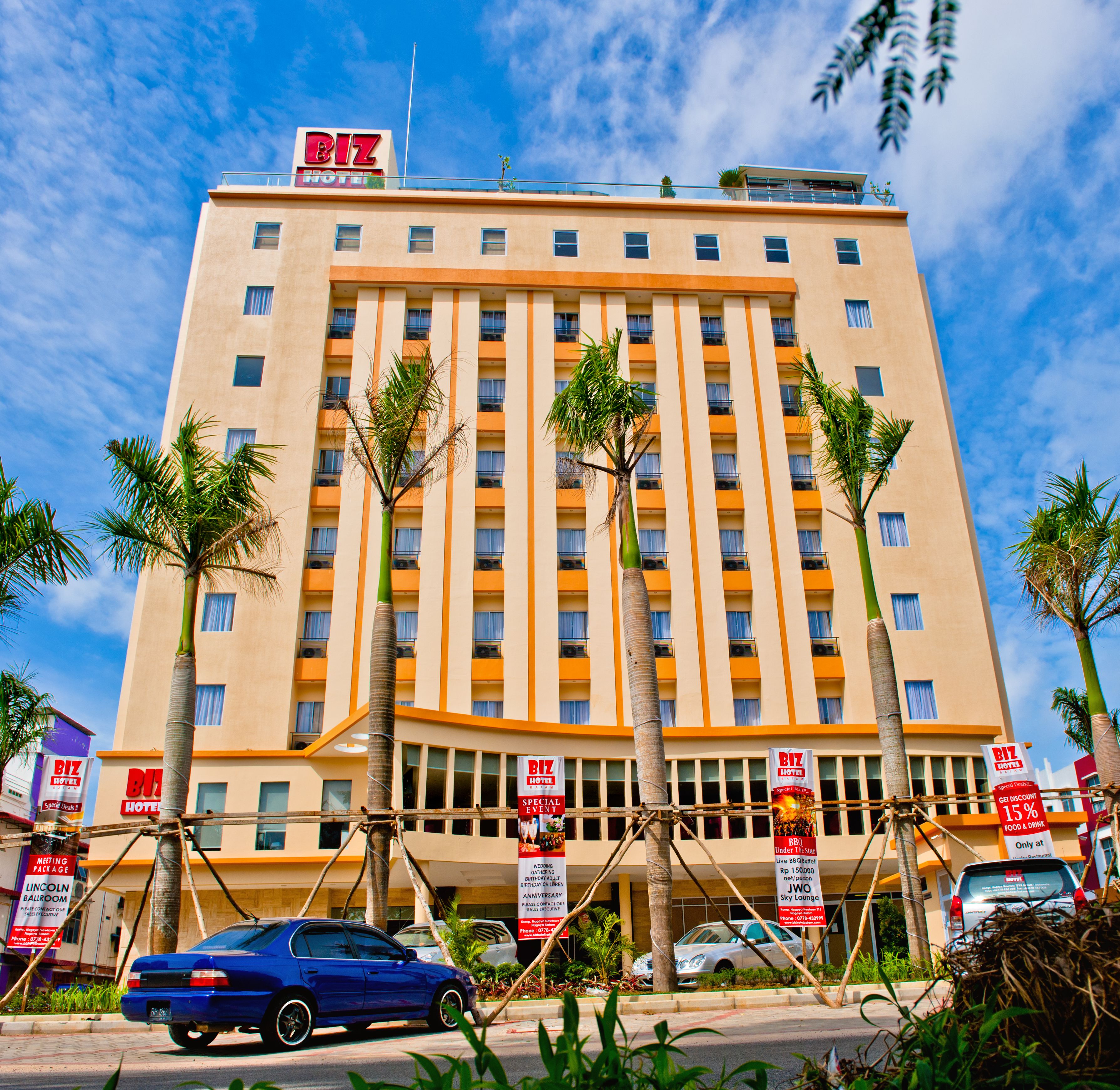 A multi-story hotel with a prominent 'BIZ HOTEL' sign, featuring a modern architectural design with vertical lines and balconies.