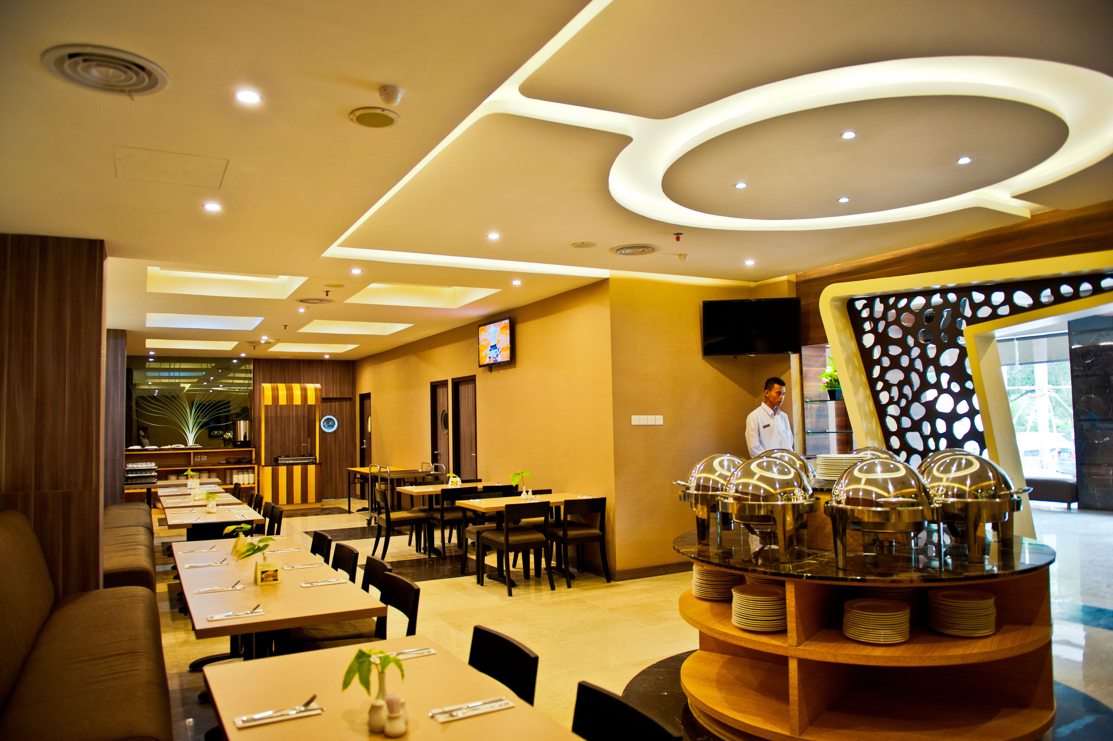A modern restaurant with a variety of seating options, including tables and booths, and a buffet area with food service stations.